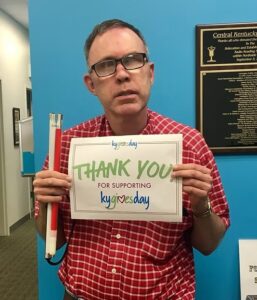 Philip a listener, member, and board member holding a sign that says "thank you"